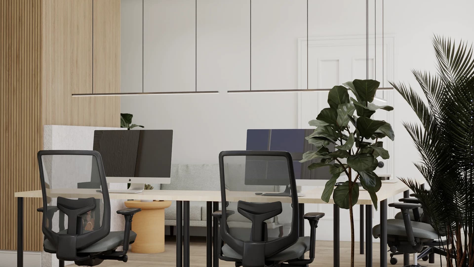 Open plan office with four workstations on white desks, dual monitors, black ergonomic mesh chairs, vertical oak wood slat accent panel on left wall, white wainscoting panel wall center, linear LED pendant overhead, large fiddle leaf fig in corner