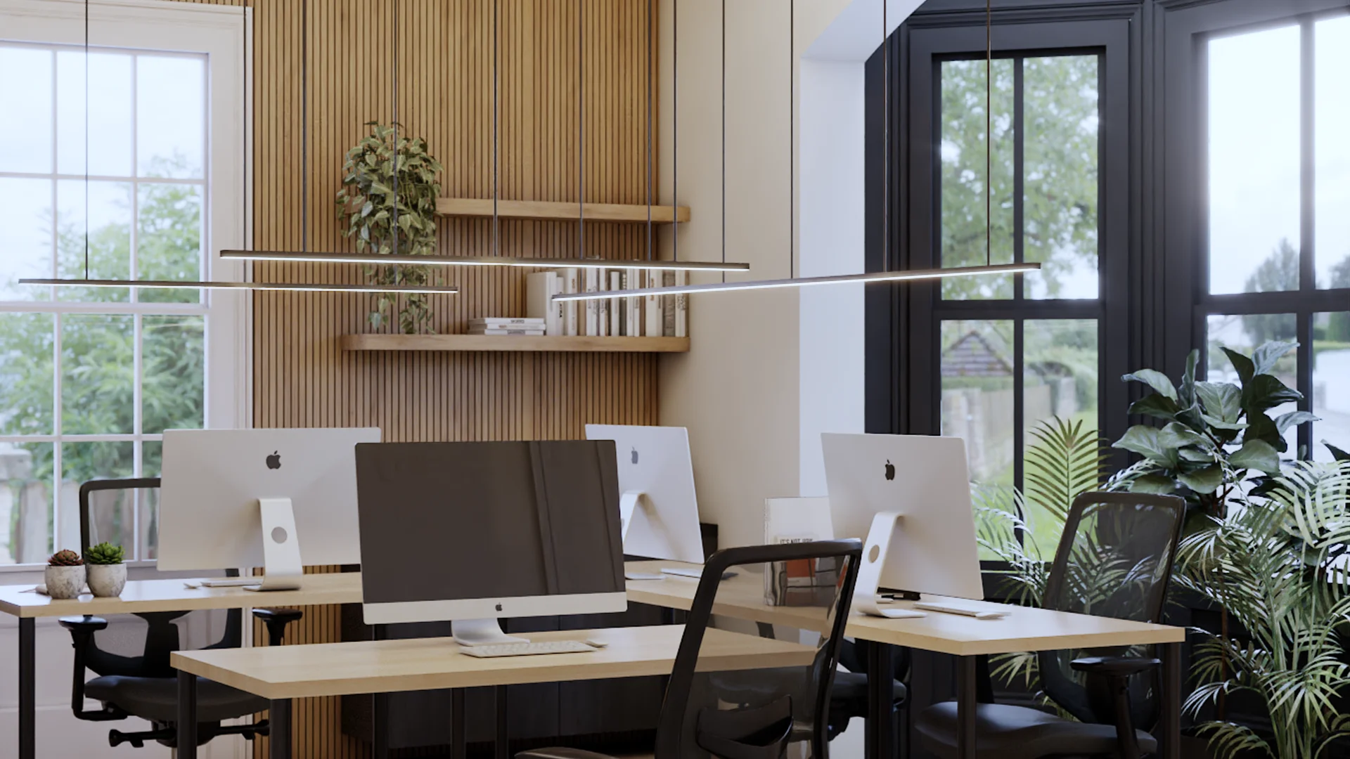 Office workstation area with oak wood slat accent wall, two floating shelves holding books and a trailing plant, four iMac computers on light oak desks, black mesh chairs, and large black-framed windows on both sides