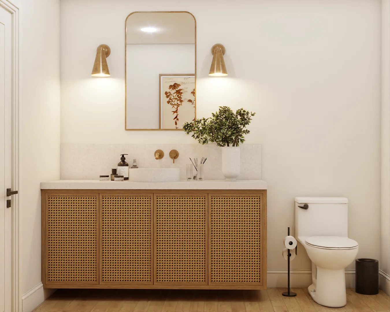 Chic bathroom featuring a rattan-fronted vanity, elegant gold wall sconces, and a decorative mirror, creating a warm and inviting space with a touch of bohemian flair. Design by Debora, an online interior design service.