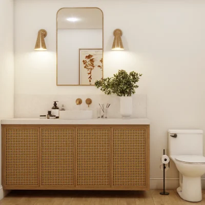 Chic bathroom featuring a rattan-fronted vanity, elegant gold wall sconces, and a decorative mirror, creating a warm and inviting space with a touch of bohemian flair. Design by Debora, an online interior design service.
