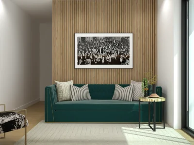 An elegant recreational area with a luxurious green sofa, a black and white photograph on a wooden slat wall, and a minimalist side table. The design combines comfort and chic style. Design by Debora, an online interior design service.